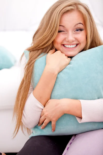 Femme souriante étreignant oreiller — Photo