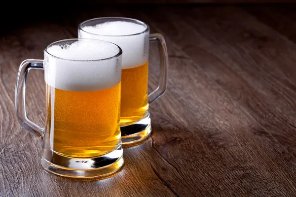 Два бокала пива на деревянном столе — стоковое фото