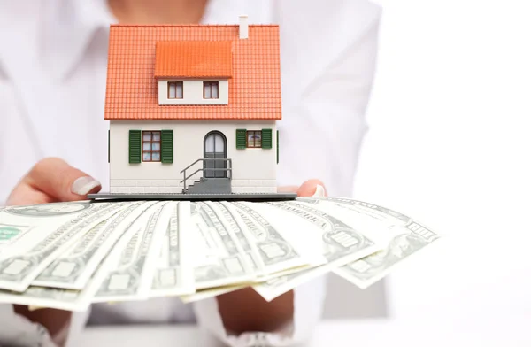 Hands with money and miniature house on a white background — Stock Photo, Image