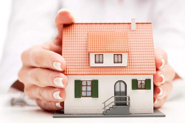 Pisture van man en vrouw handen met papier huis — Stockfoto