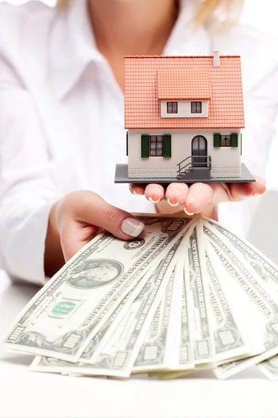 Hands with money and miniature house on a white background — Stock Photo, Image