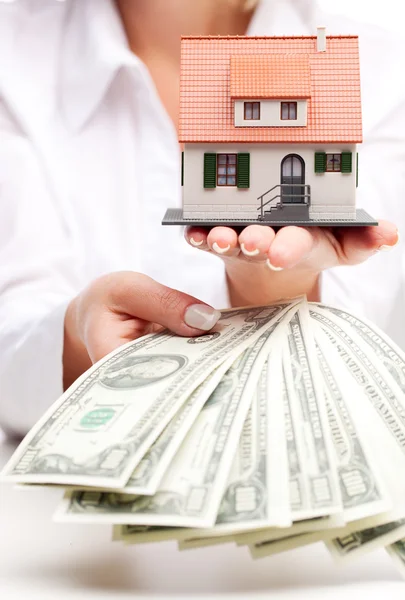 Hands with money and miniature house on a white background — Stock Photo, Image