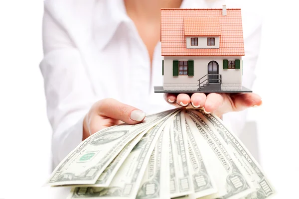 Hands with money and miniature house on a white background — Stock Photo, Image