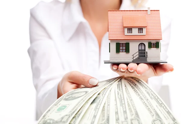 Hands with money and miniature house on a white background — Stock Photo, Image