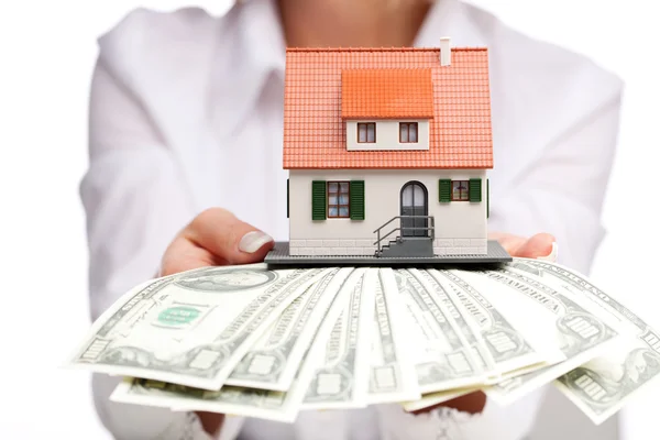 Hands with money and miniature house on a white background — Stock Photo, Image