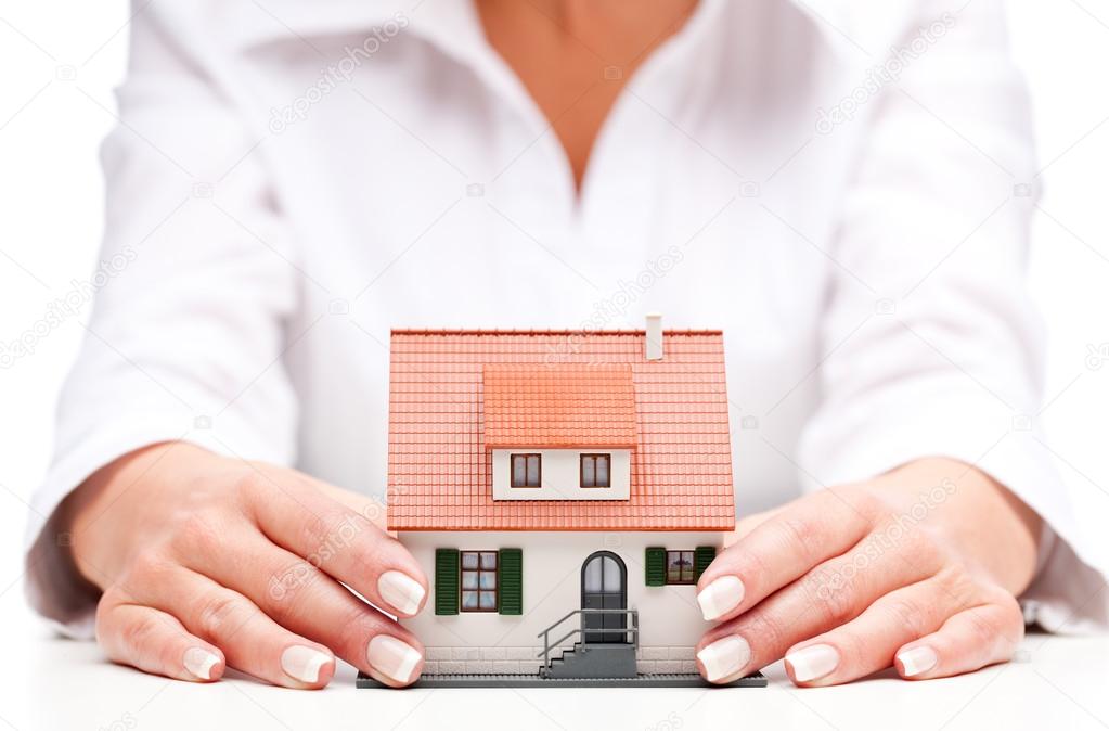 Pisture of man and woman hands holding paper house