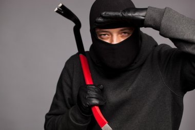 Burglar with a crowbar on the shoulder. clipart