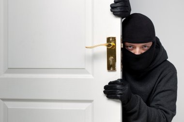 Burglar sneaking in a open house door clipart