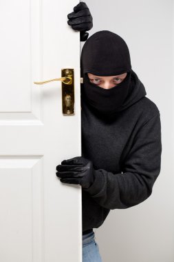 Burglar sneaking in a open house door clipart