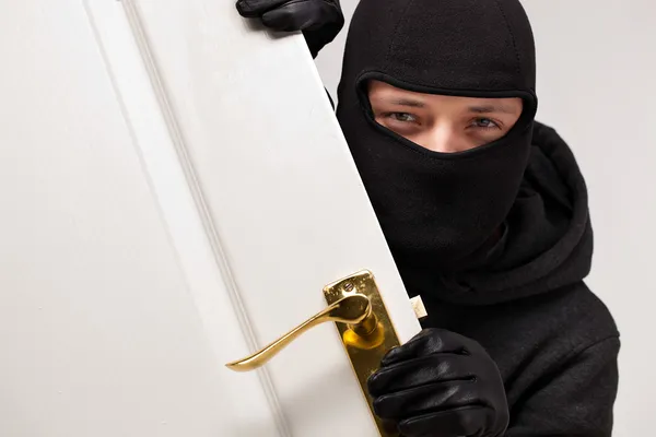 Inbrottstjuv smyga i en öppet hus dörr — Stockfoto