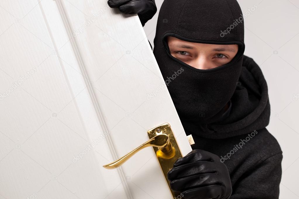 Burglar sneaking in a open house door