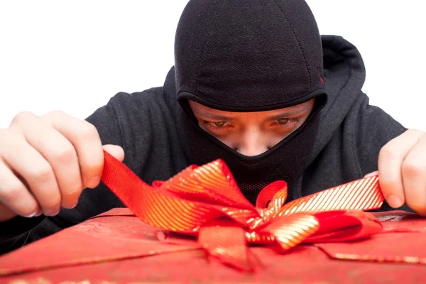 Bandido segurando um presente de Natal embrulhado — Fotografia de Stock