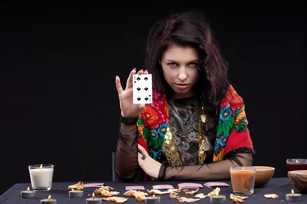 Attractive young fortune teller holdin card — Stock Photo, Image