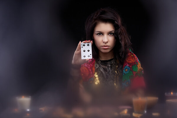 Attractive young fortune teller holdin card
