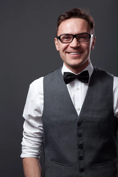 Handsome young man staying against gray wall — Stock Photo, Image