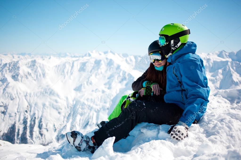Young happy couple in snowy mountains.