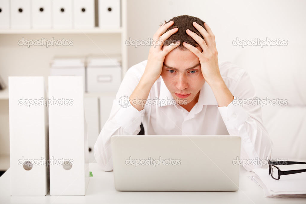 Despairing businessman sitting at desk