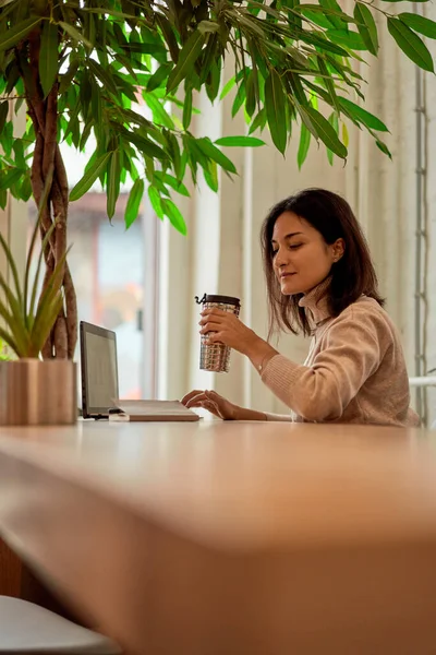 Freelancer feminino bebendo café durante o trabalho — Fotografia de Stock