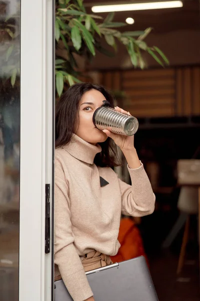 Femme pigiste boire du café dans l'embrasure de la porte — Photo