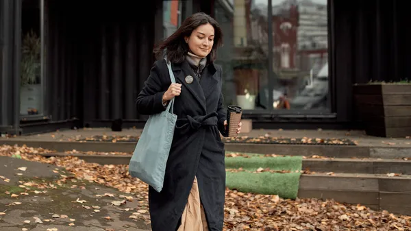 Mulher com bebida takeaway andando na rua — Fotografia de Stock