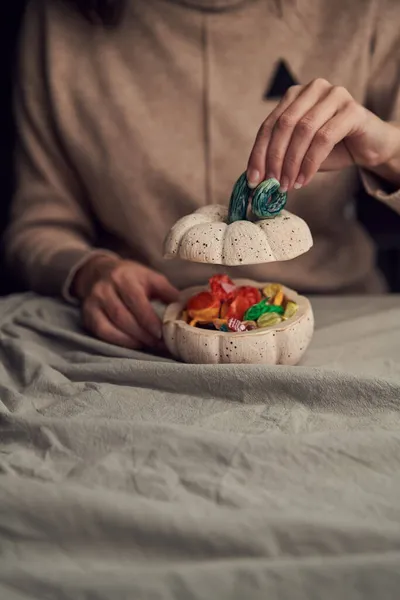 Femme méconnaissable montrant des bonbons dans une boîte à la main — Photo
