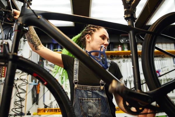 Getatoeëerde monteur bevestigingsfiets in werkplaats — Stockfoto