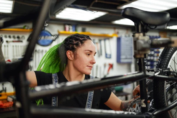 心满意足的女人在修理店修理自行车 — 图库照片