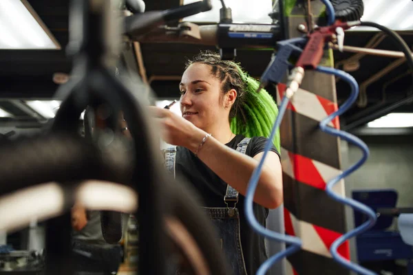 Kvinnlig mästare ler under reparationsarbeten i garage — Stockfoto
