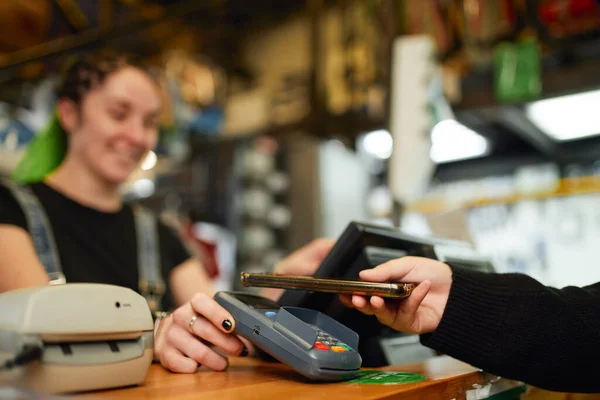 지불 단말기를 통해 스마트폰으로 지불하는 고객 — 스톡 사진