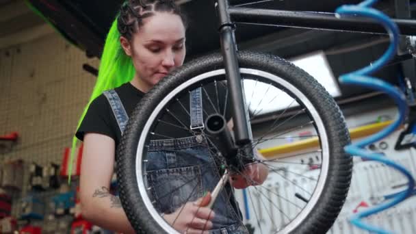 Alternatif kadın atölyede bisiklet tamir ediyor. — Stok video