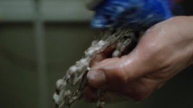 Ekin teknisyeni bisiklet zincirini yıkıyor.