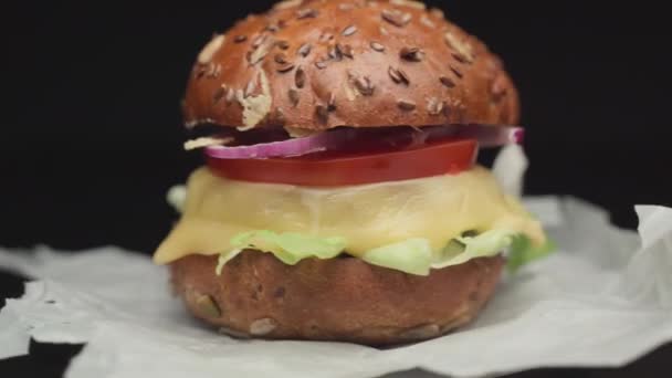 Handgemaakte hamburger draait op verfrommeld papier — Stockvideo