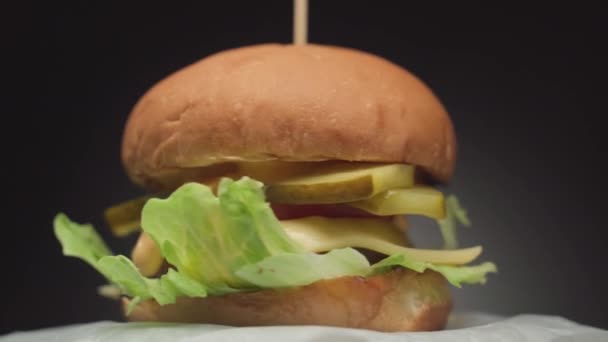 Burger maison fait à la main tourne sur papier froissé — Video