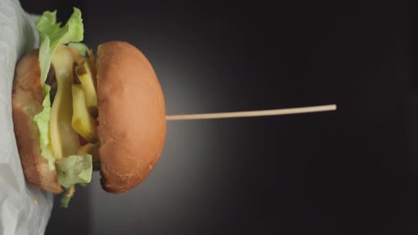 El yapımı ev yapımı hamburger, buruşuk kağıt üzerinde döner. — Stok video