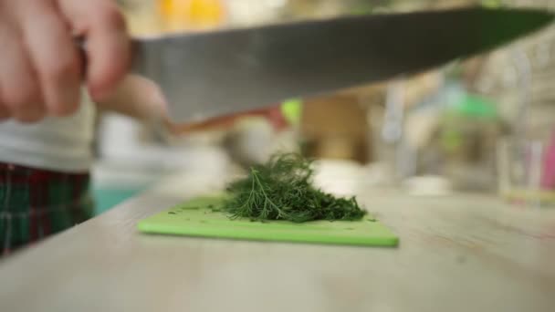 Crop man chopping herbs on cutting board in kitchen — Stock Video