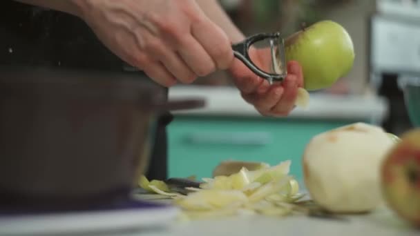 Mulher de colheita descascando maçã à mesa na cozinha — Vídeo de Stock