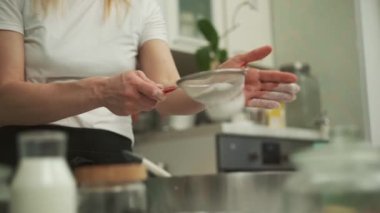 Pasta hazırlıkları sırasında un karıştıran yüzü olmayan bir kadın.