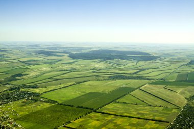 Aerial view of a green rural area under blue sky clipart