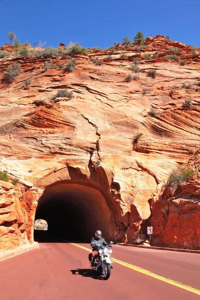Motorcyclist leaves the tunnel in the sandstone hill — Stock Photo, Image