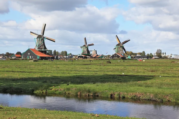 Three windmills on a meadow, among deep channels — Stock Photo, Image