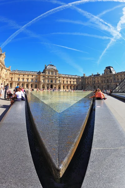 Tourists resting on a granite fence fountain — Stock Photo, Image