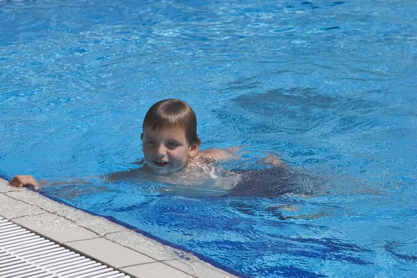 Niño se baña en la piscina — Foto de Stock