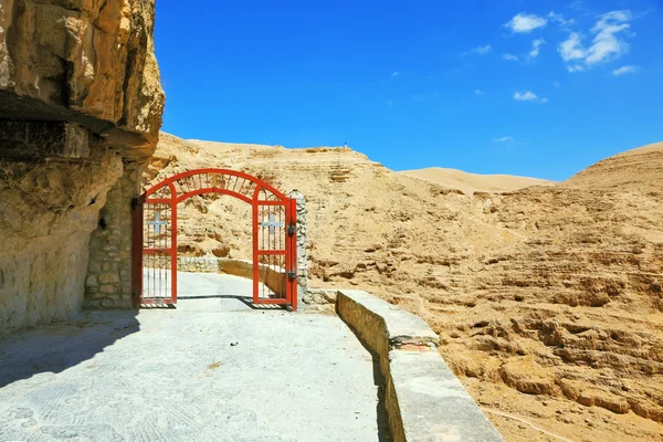 O portão vermelho em uma estrada de montanha — Fotografia de Stock