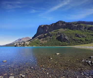  parlak mavi su ve kayalık sahil.