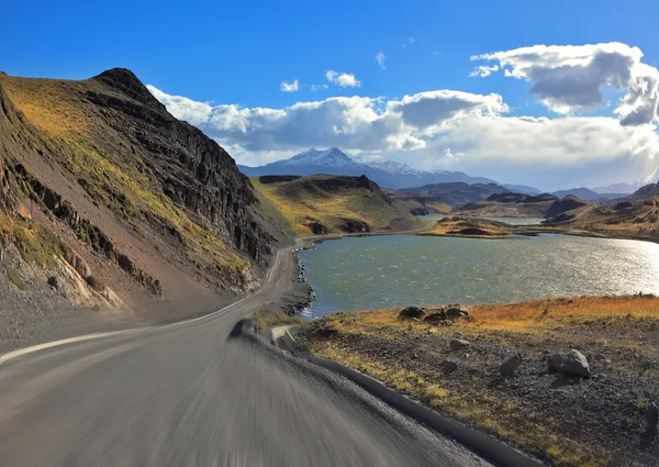 Uma estrada de cascalho corre à beira do lago — Fotografia de Stock