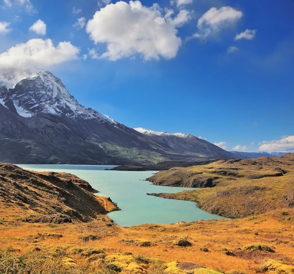 Schneebedeckte Berggipfel und See mit smaragdgrünem Wasser — Stockfoto