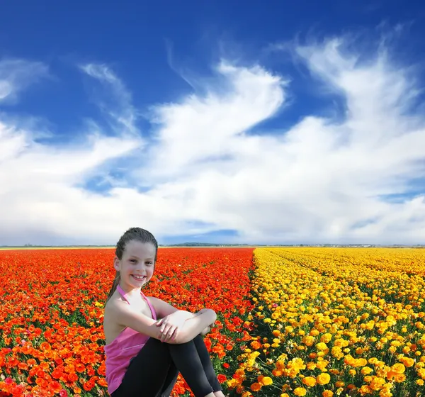 Flickan poserar och leende i ett fält — Stockfoto