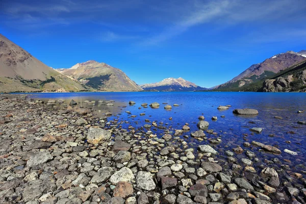 El lago azul poco profundo con una playa pedregosa —  Fotos de Stock