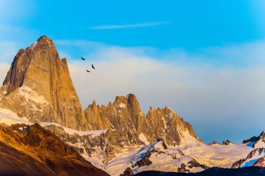 Büyük And Akbabaları gökyüzünde uçar. Güneşin doğuşuyla aydınlanan muhteşem dağ sırası. Fitzroi - Patagonya 'da dağ zirvesi. Ekstrem, aktif ve fotoğraf turizmi kavramı