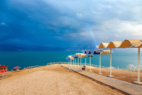 Morze Martwe Izraelskie Wybrzeże Malownicza Plaża Jasnymi Parasolami Mroczne Niebo — Zdjęcie stockowe